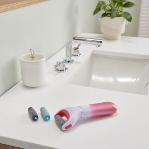Amope pedi perfect electronic foot file on bathroom counter with two replacement roller refill heads
