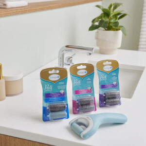 Amope pedi perfect electronic foot file on bathroom counter with three packages of two replacement roller refill heads each