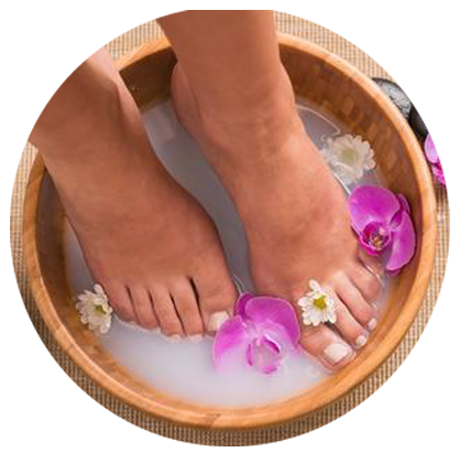 Feet in spa bowl with flowers for pedicure